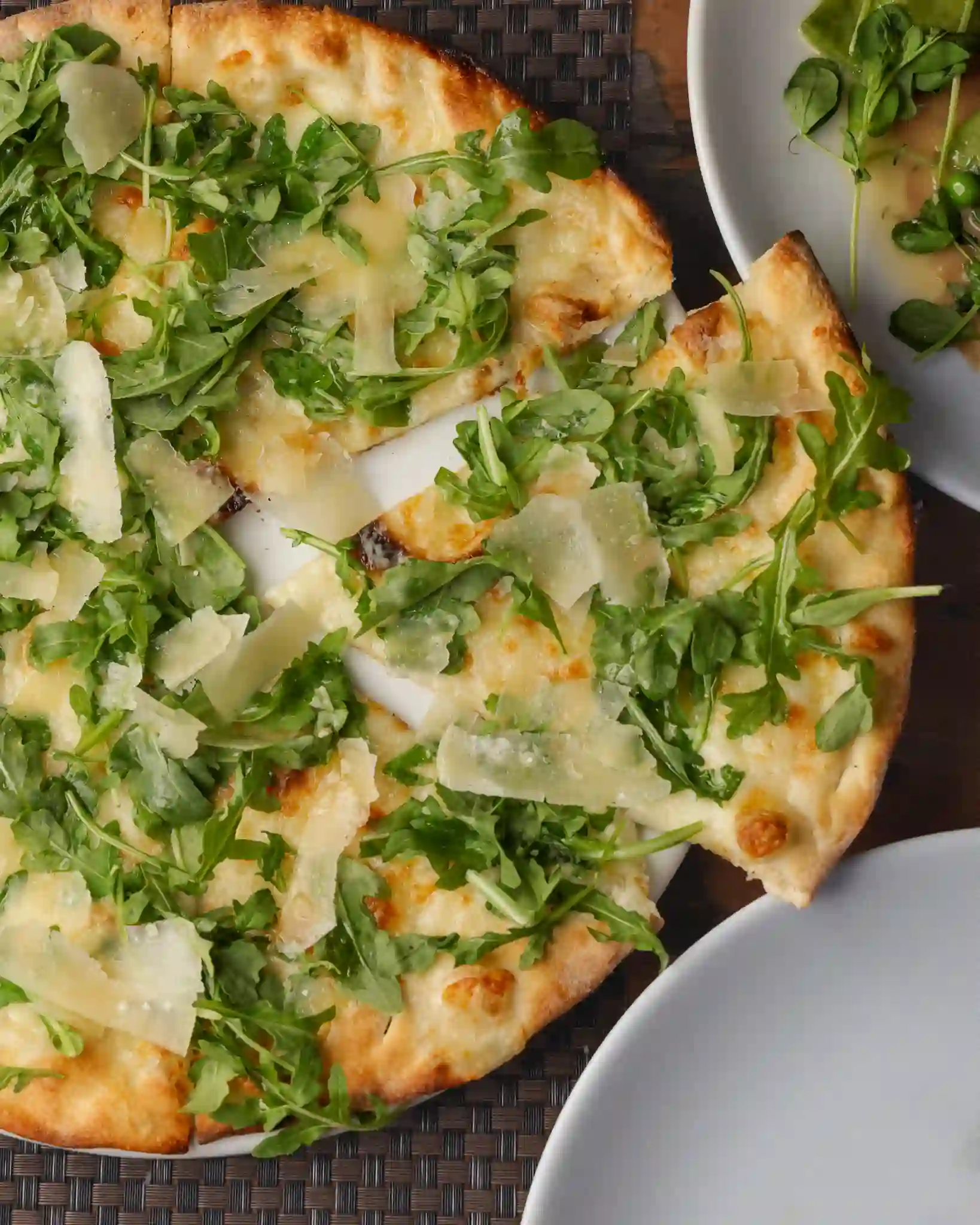 White pizza with arugula and shaved Parmigiano